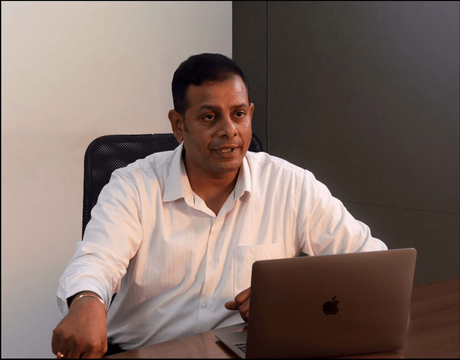 Sudheer Gudla seated at a desk with his laptop